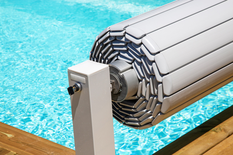 pool cover rolled up above pool