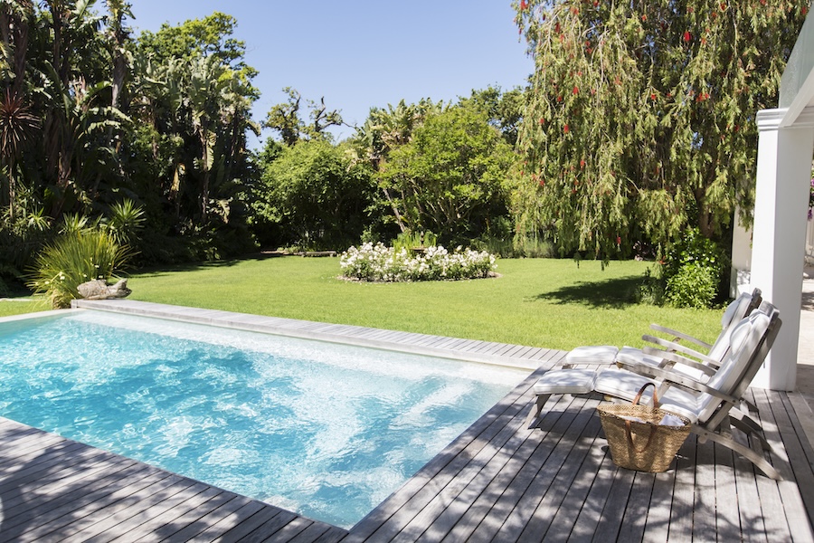 Lawn chairs overlooking backyard and swimming pool