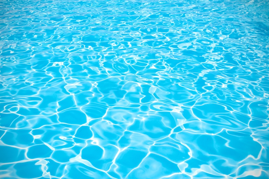 Blue pool water with sun reflections